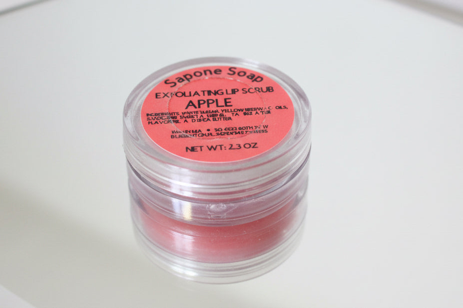 Lip scrub container labeled 'Apple' on a mirror
